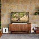 Sonos Arc Soundbar in white on a console table in front of a televsion