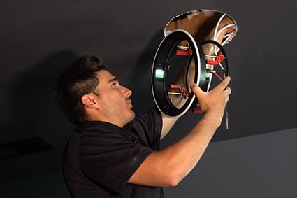 Audio Advice installer installing an in-wall speaker frame into a ceiling.